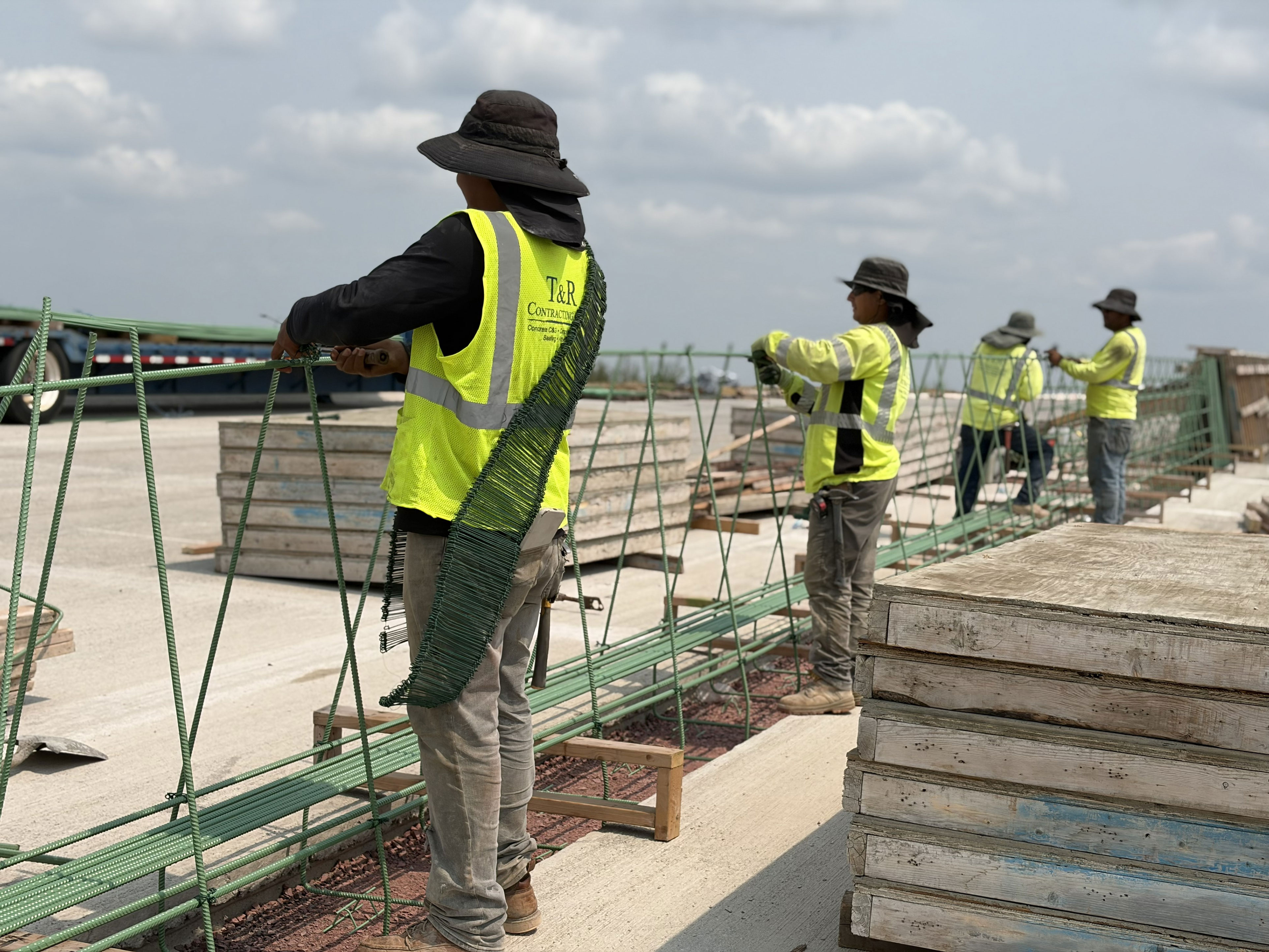 Construction crews assembling the bridge approach barrier walls. 